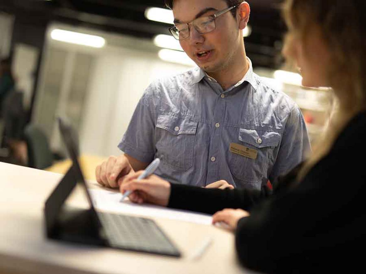 University of Adelaide staff member assisting a student