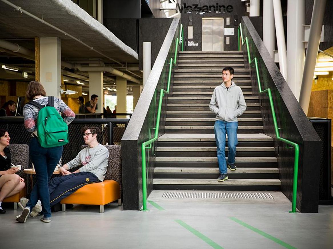 Student walking down the stairs at Hub Central