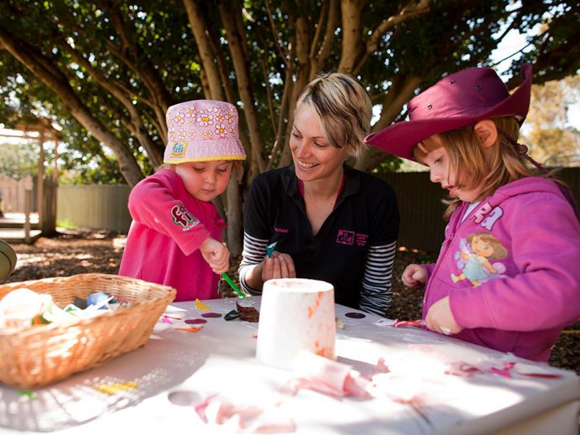 Children painting with carer