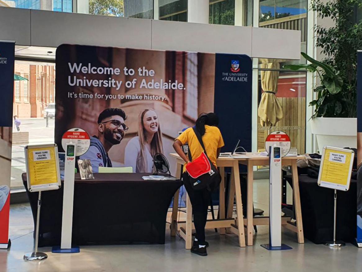 Welcome desk with student asking for help
